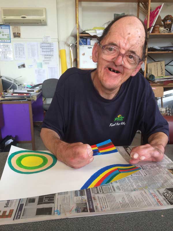 Robert, an artist at Artspace, works on one of his brightly coloured geometric designs