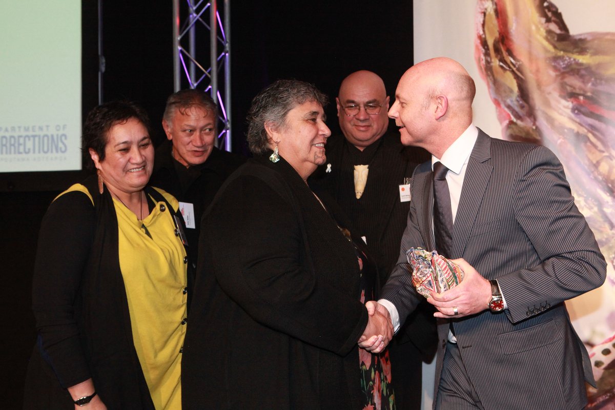 Ray Smith presents the Big 'A' Prison Arts Community Award to recipients from Waihopai Runaka