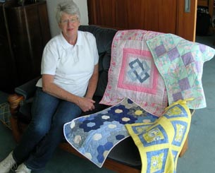 Volunteer Justine Jones with some of the quilts made for the neonatal ward at Middlemore Hospital