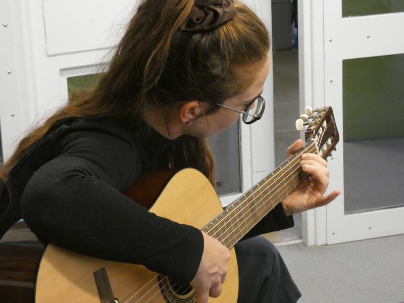 Music therapist Ella Polczyk plays her guitar