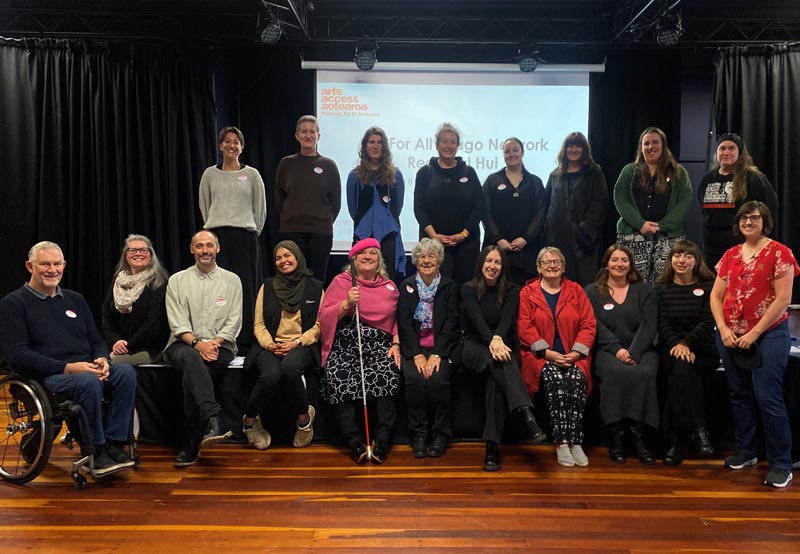 A group of 19 Arts For All Otago Network members at a hui facilitated by Katie Querin, standing far right