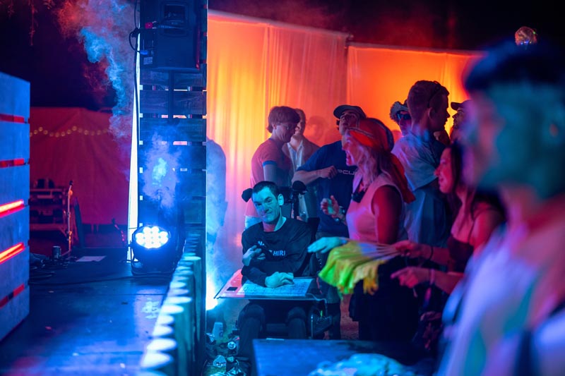 A festival-goer smiles at the camera from across the stage, surrounded by the crowd during the festival's closing set Photo: Lucas Perelini