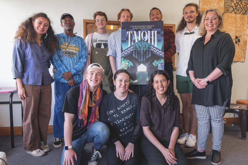 Ruby Macomber, front right, an nine other people standing around a banner advertising Taiohi Inside