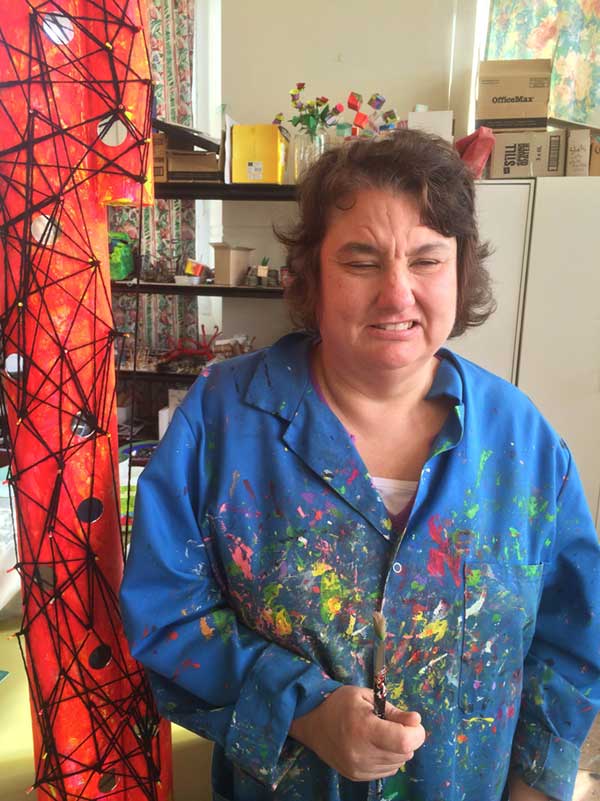 Kellie, an Artspace artist, stands beside part of a sculpture she is working on