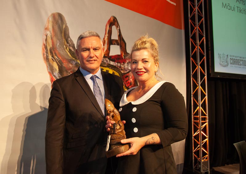 Beth Hill and Kelvin Davis stand together and smile as Beth receives her award