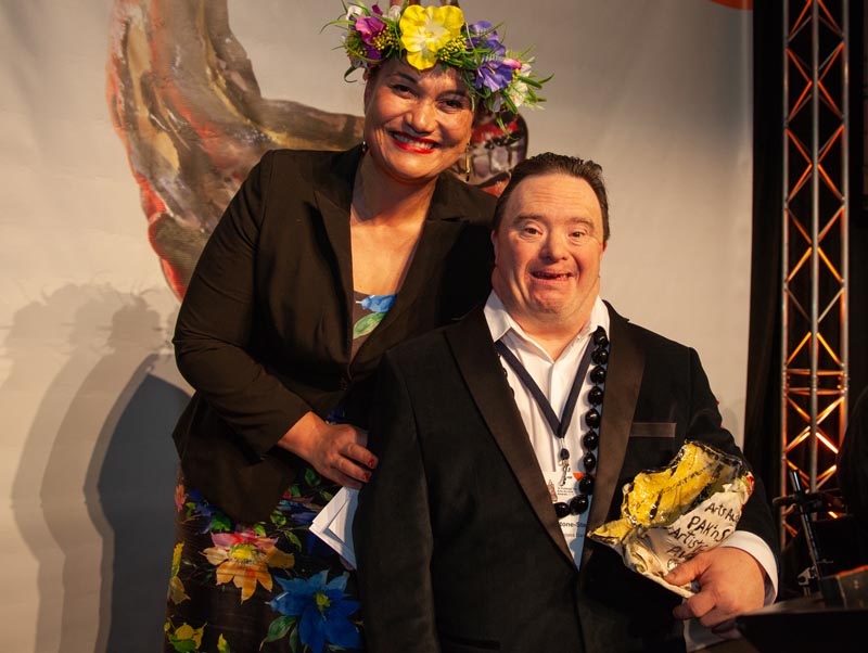 Jesse smiles brightly at the camera as he recieves his award.