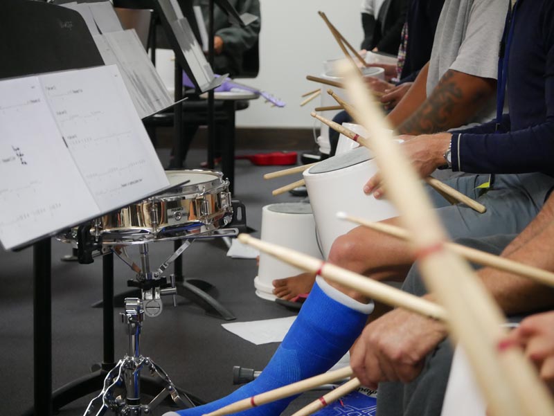 Participants in the Platform Programme play bucket drums during a music workshop at Christchurch Men’s Prison.