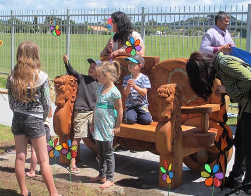 Children gather around the seat carved in memory of Kiara Morgan