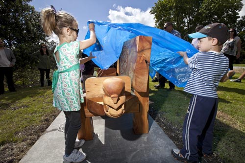 Children unwrap one of the carved seats